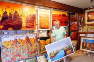 Resident showing his landscape paintings on the Bundeena Art Trail - Bill Peach Journeys